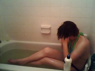 eine sissy trägt einen Badeanzug in der Badewanne